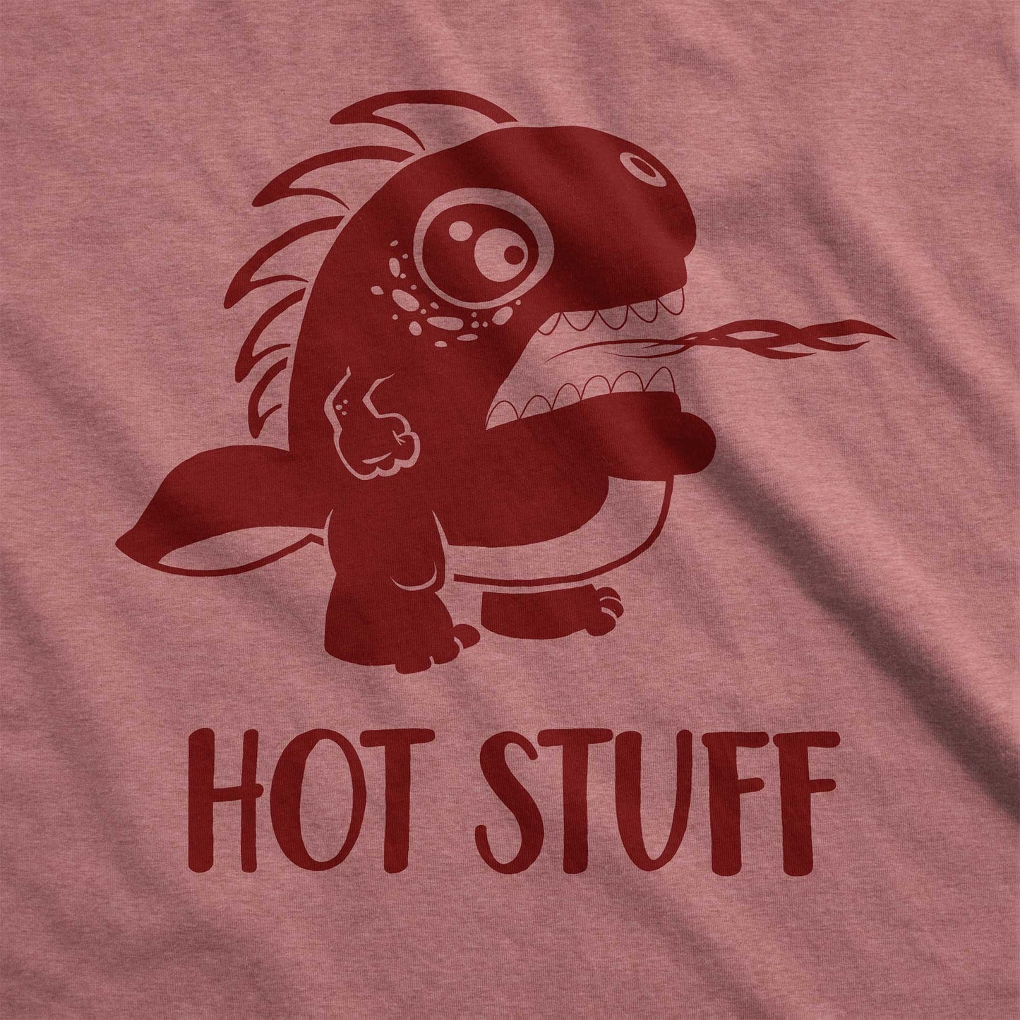 A heather mauve Bella Canvas swatch wearing a cute cartoon monster that is belching fire with the words hot stuff.