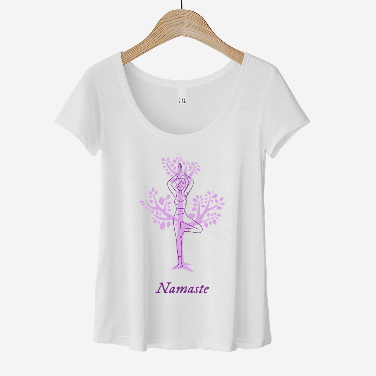 A hanging white District 7501 scoop neck t-shirt featuring a cartoon woman doing the tree pose in front of a tree silhouette and the words namaste below her.