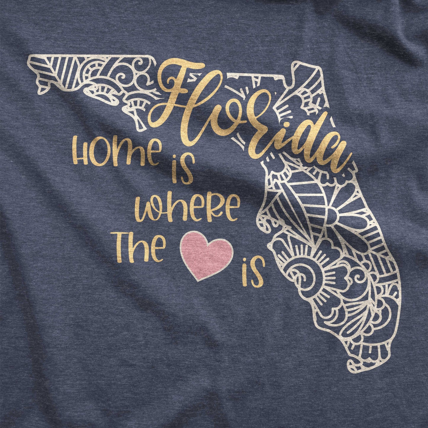 A heather navy Bella Canvas swatch featuring a mandala in the shape of Florida with the words home is where the heart is.