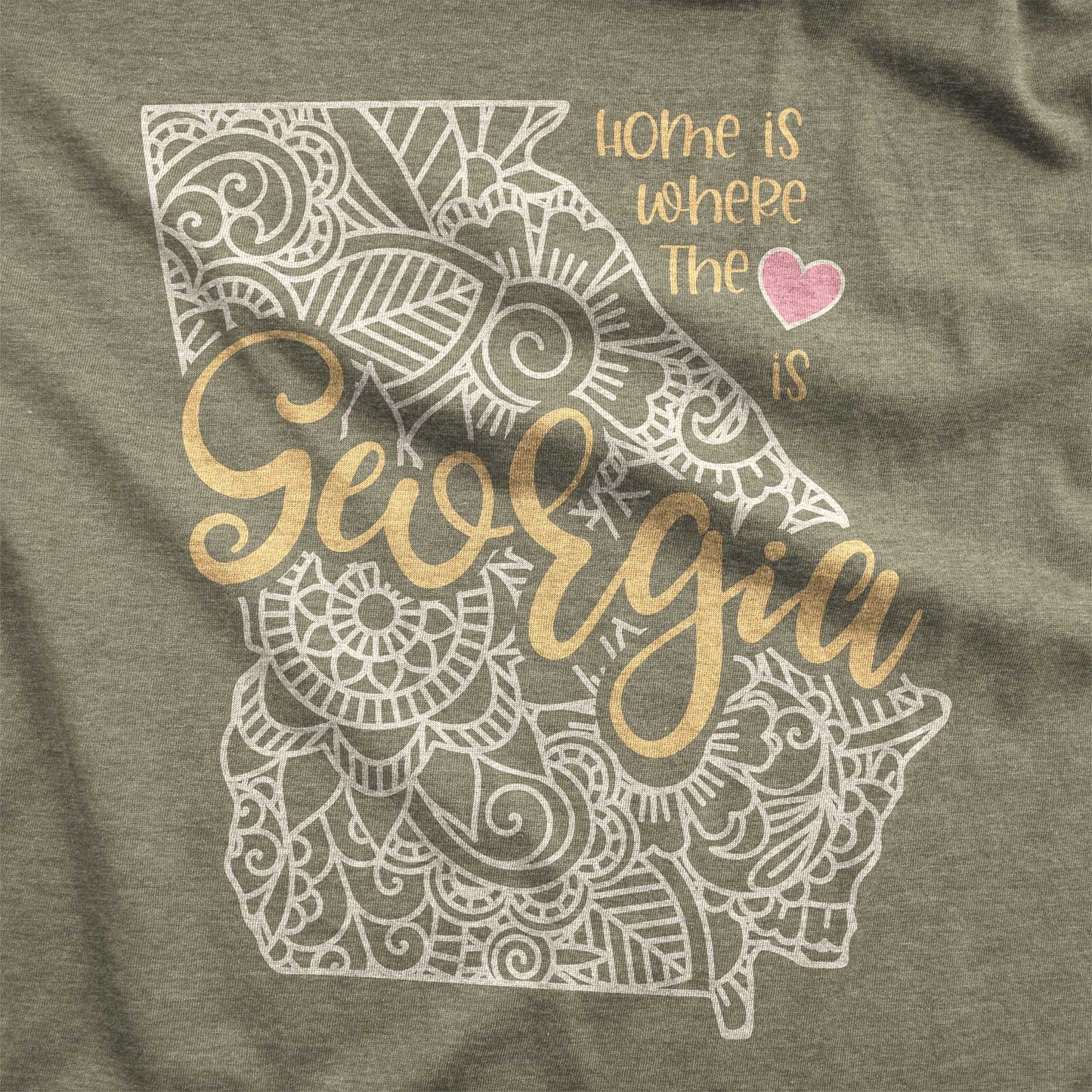 A heather olive Bella Canvas swatch featuring a mandala in the shape of Georgia with the words home is where the heart is.