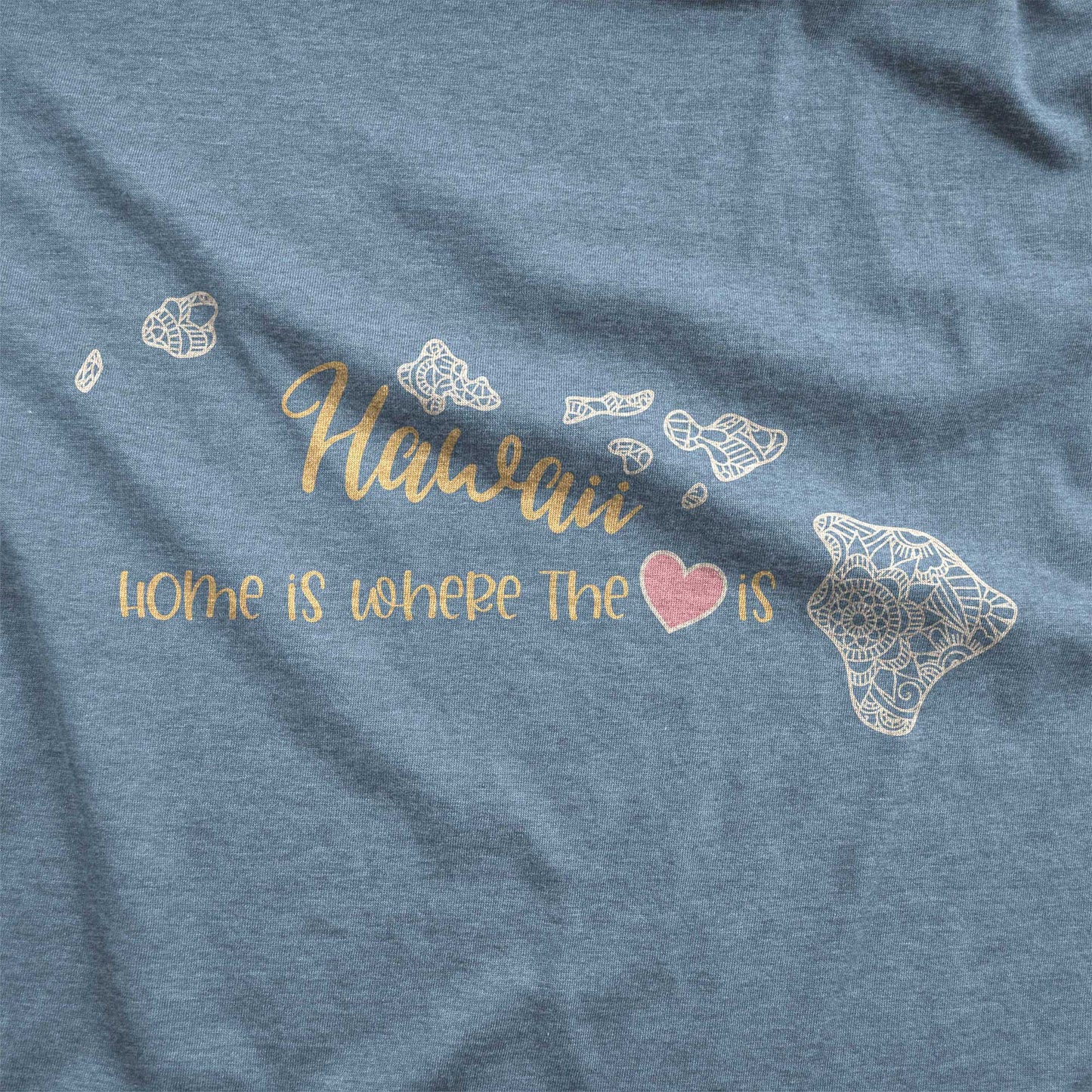 A heather slate Bella Canvas swatch featuring a mandala in the shape of Hawaii with the words home is where the heart is.