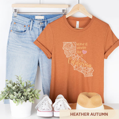 A hanging heather autumn Bella Canvas t-shirt featuring a mandala in the shape of California with the words home is where the heart is.