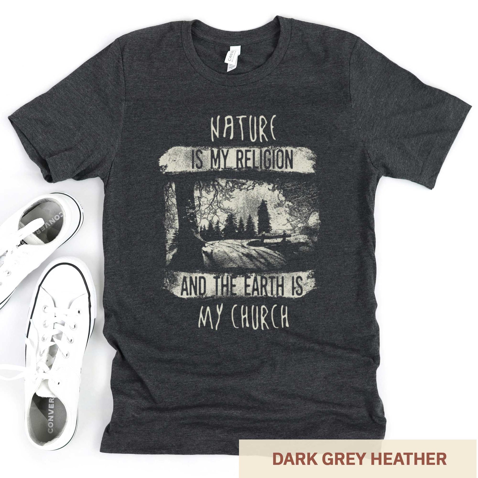 A dark grey heather Bella Canvas t-shirt featuring fields and a forest with the words nature is my religion and the earth is my church.
