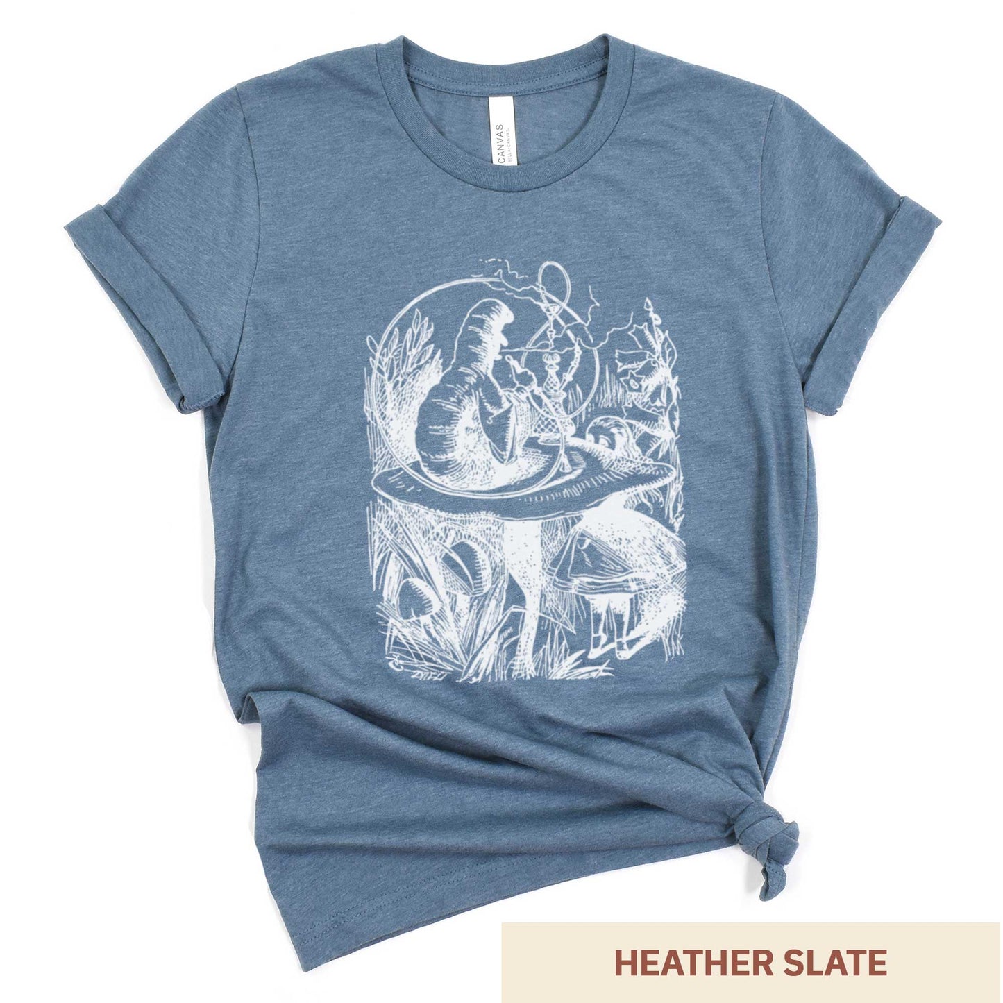 A heather slate Bella Canvas t-shirt featuring the John Tenniel illustration of Alice in Wonderland meeting the caterpillar who is sitting on a mushroom.