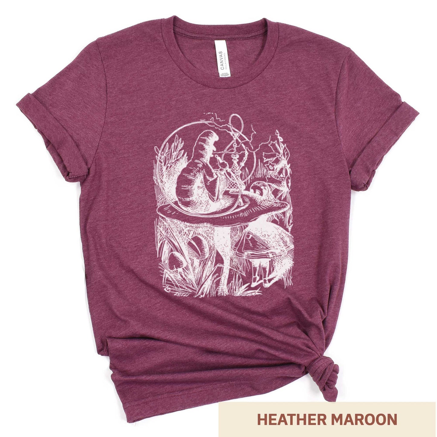 A heather maroon Bella Canvas t-shirt featuring the John Tenniel illustration of Alice in Wonderland meeting the caterpillar who is sitting on a mushroom.