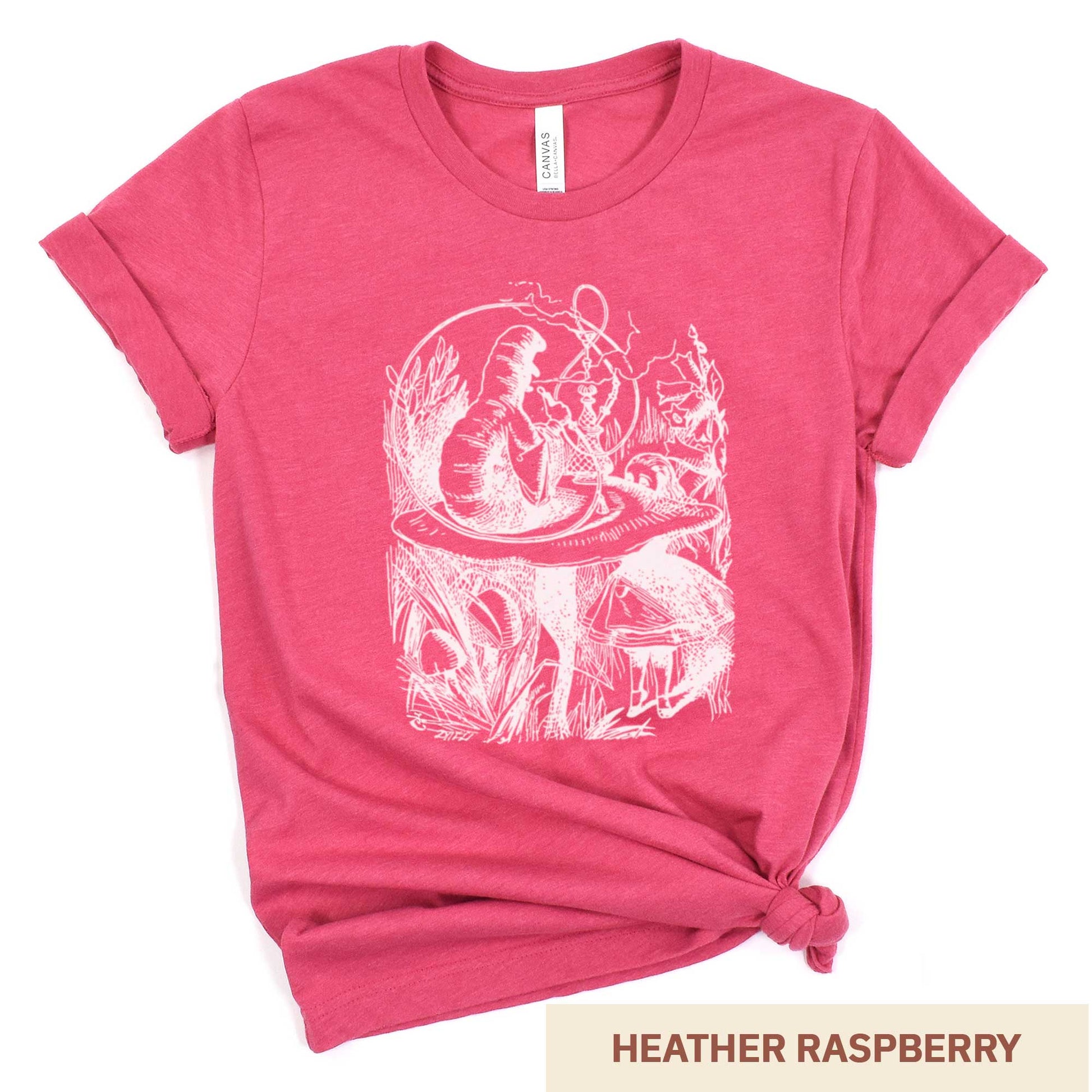 A heather raspberry Bella Canvas t-shirt featuring the John Tenniel illustration of Alice in Wonderland meeting the caterpillar who is sitting on a mushroom.