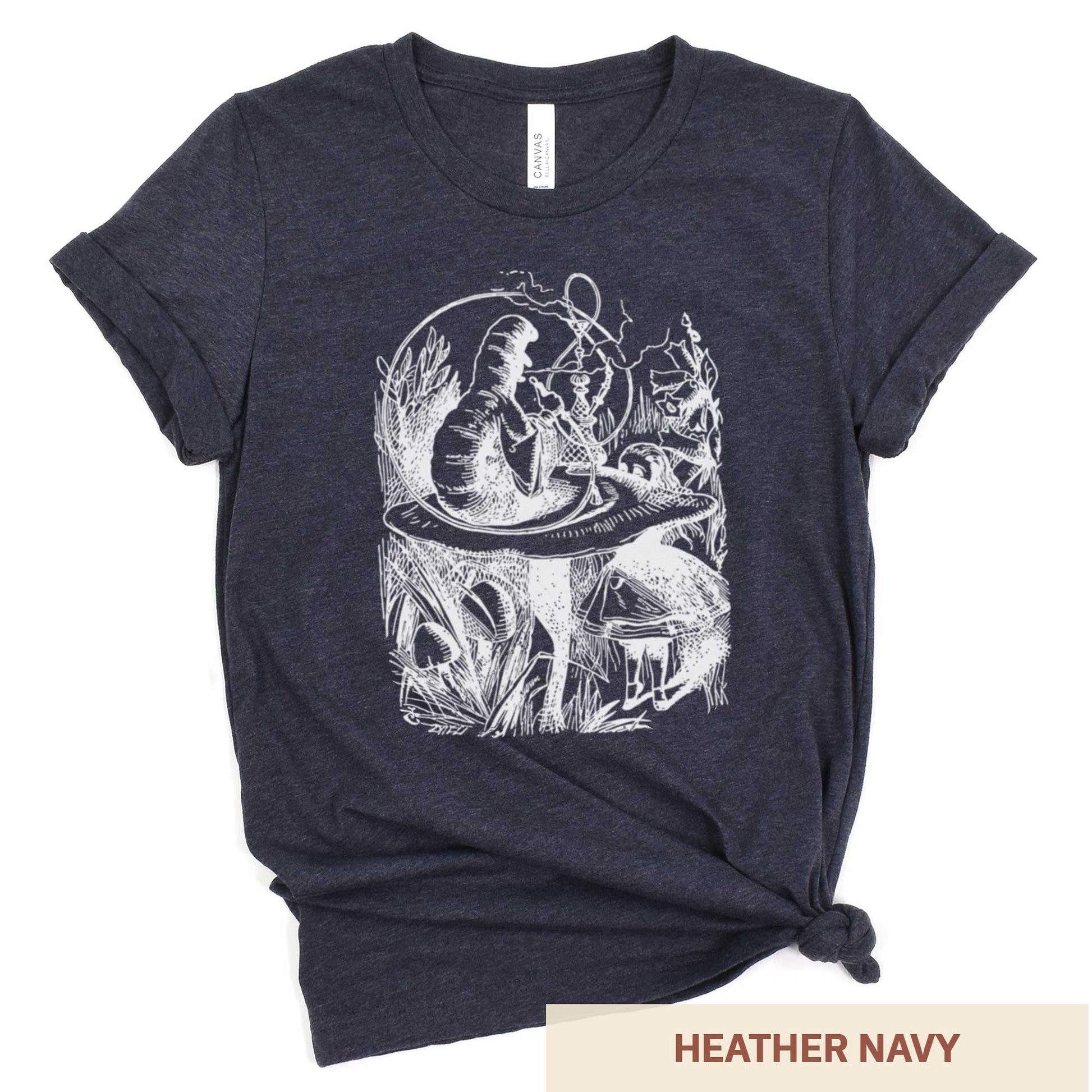 A heather navy Bella Canvas t-shirt featuring the John Tenniel illustration of Alice in Wonderland meeting the caterpillar who is sitting on a mushroom.
