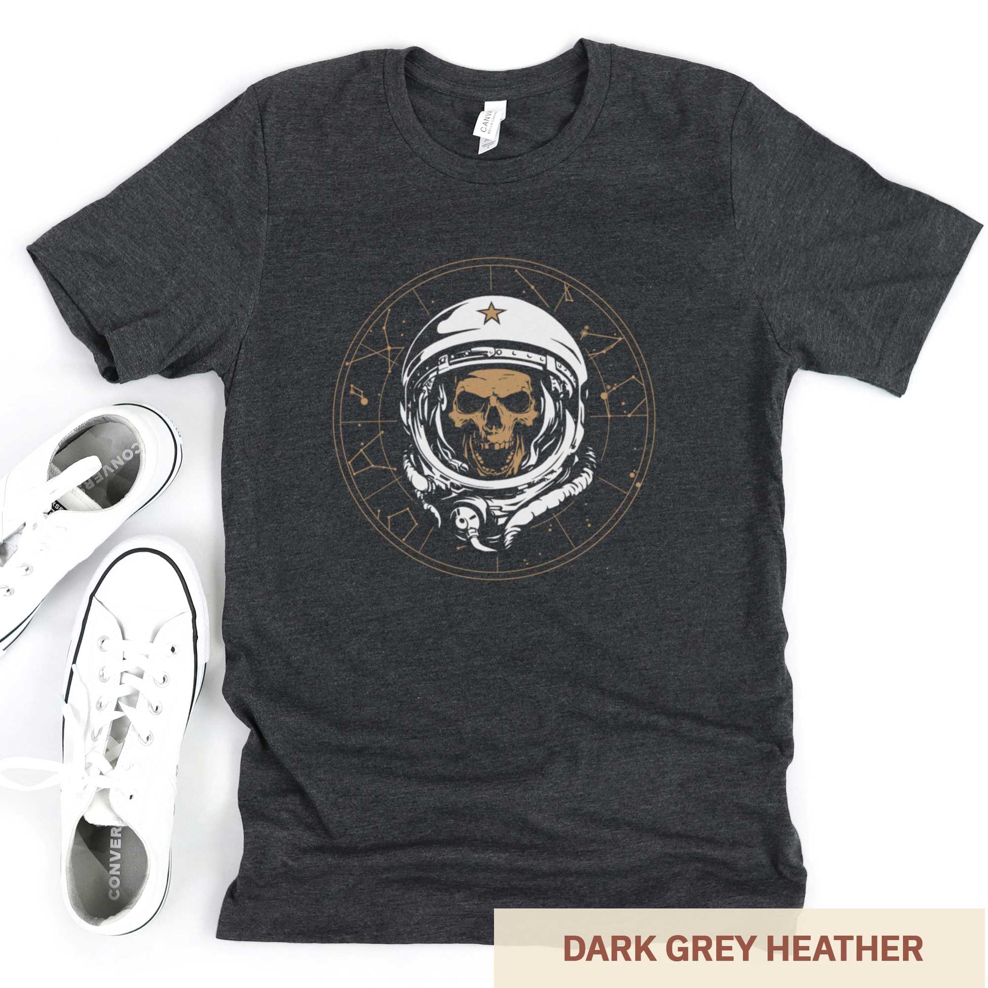 A dark grey heather Bella Canvas t-shirt featuring a skull of astronaut breaking through the constellations in space.