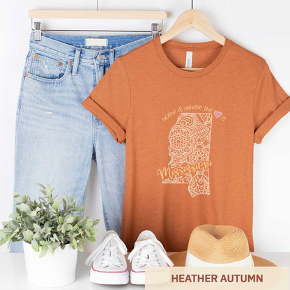 A hanging heather autumn Bella Canvas t-shirt featuring a mandala in the shape of Mississippi with the words home is where the heart is.