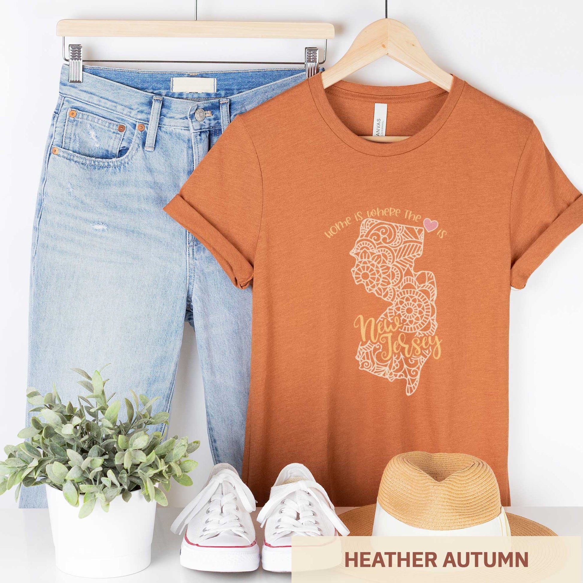 A hanging heather autumn Bella Canvas t-shirt featuring a mandala in the shape of New Jersey with the words home is where the heart is.