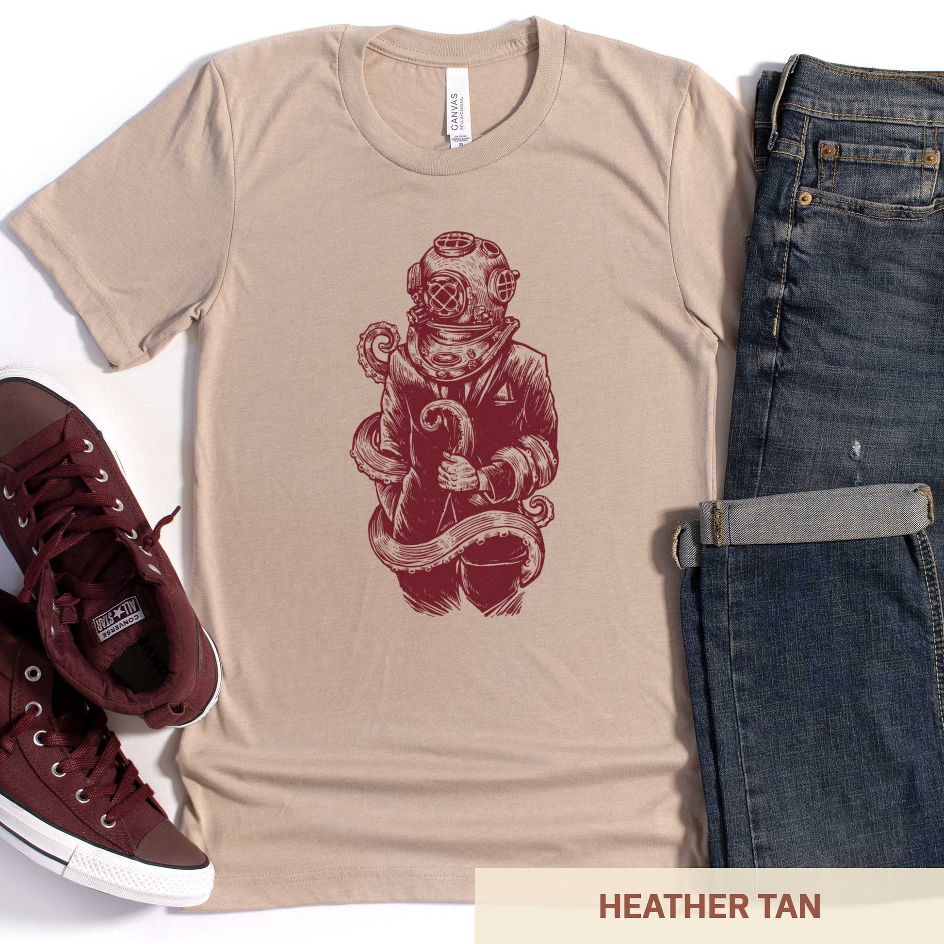 A heather tan Bella Canvas t-shirt featuring a figure in a business suit wearing a vintage diver's helmet with octopus tentacles wrapped around them.