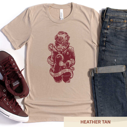 A heather tan Bella Canvas t-shirt featuring a figure in a business suit wearing a vintage diver's helmet with octopus tentacles wrapped around them.