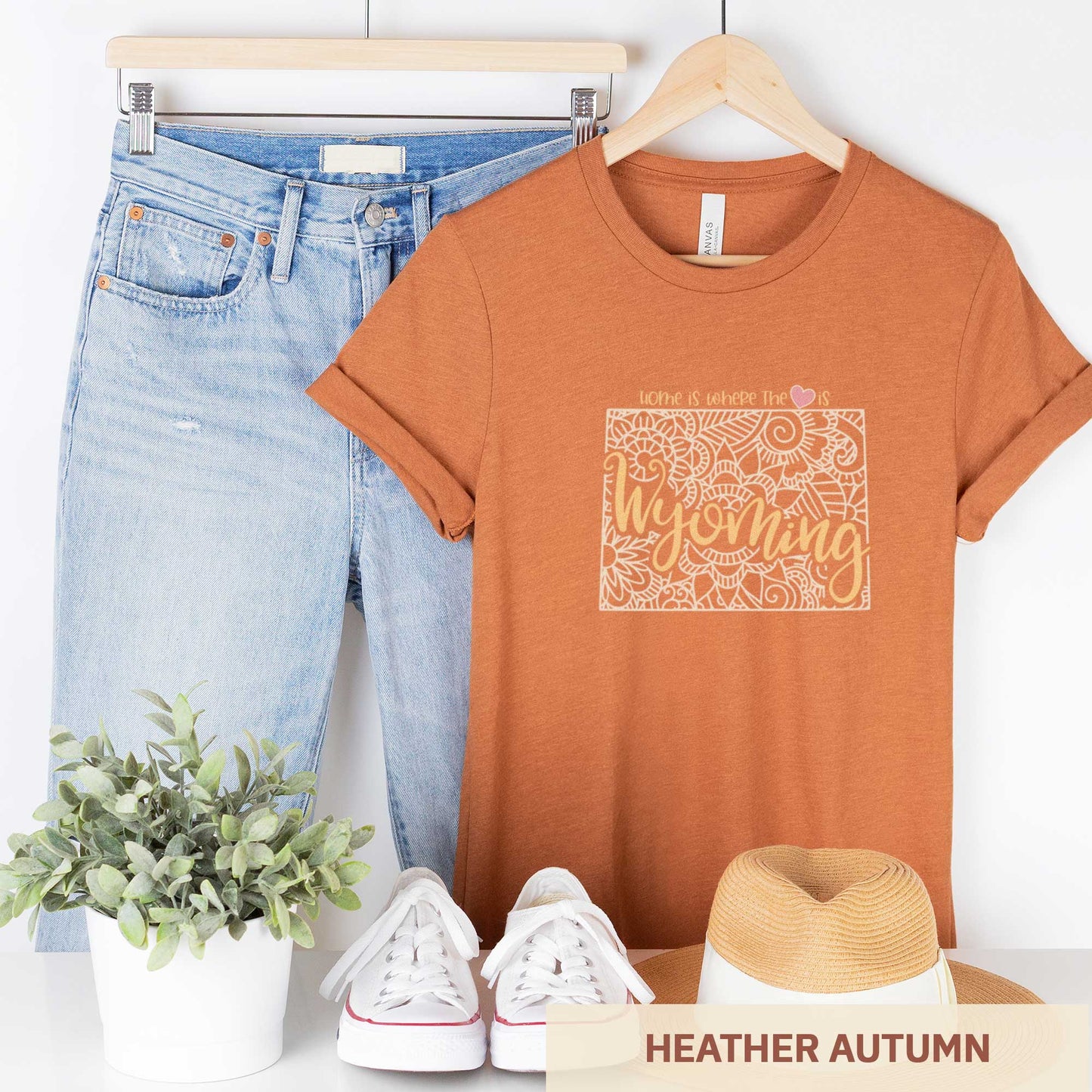 A hanging heather autumn Bella Canvas t-shirt featuring a mandala in the shape of Wyoming with the words home is where the heart is.
