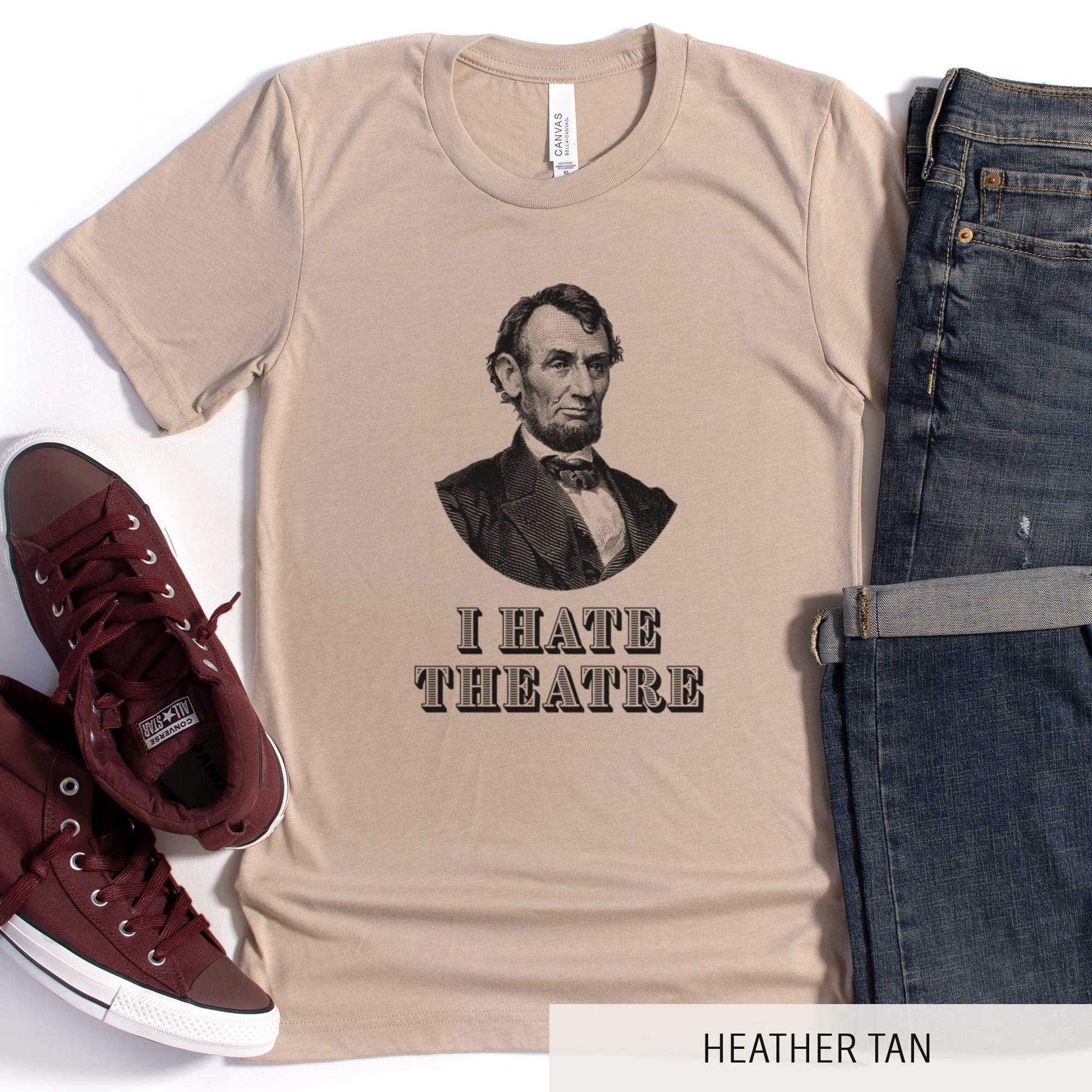 A heather tan Bella Canvas t-shirt featuring a vintage illustration of Abraham Lincoln with the words I hate theatre below it.