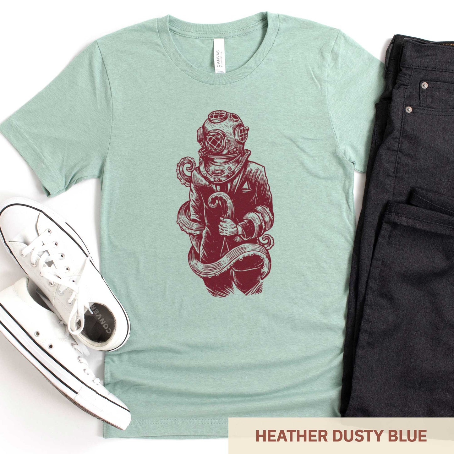 A heather dusty blue Bella Canvas t-shirt featuring a figure in a business suit wearing a vintage diver's helmet with octopus tentacles wrapped around them.