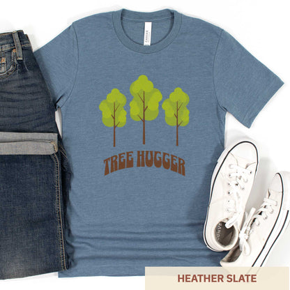 A heather slate Bella Canvas t-shirt featuring three trees and the words tree hugger.