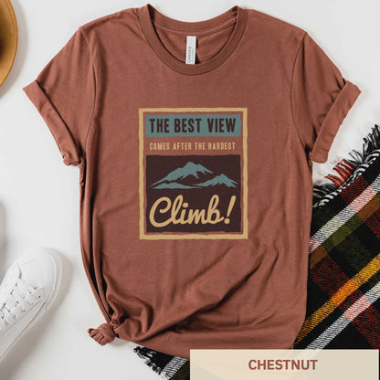 A chestnut Bella Canvas t-shirt that features mountains and the words the best view comes after the hardest climb.