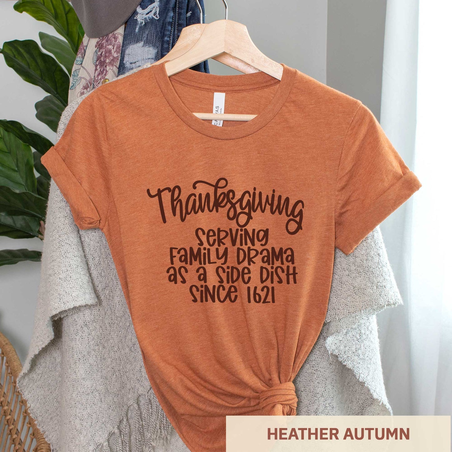 A hanging heather autumn Bella Canvas t-shirt featuring the words thanksgiving serving family as a side dish since 1621.