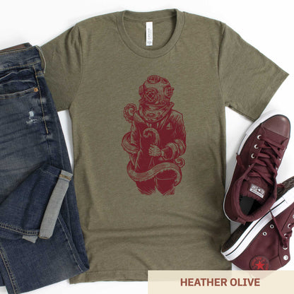 A heather olive Bella Canvas t-shirt featuring a figure in a business suit wearing a vintage diver's helmet with octopus tentacles wrapped around them.