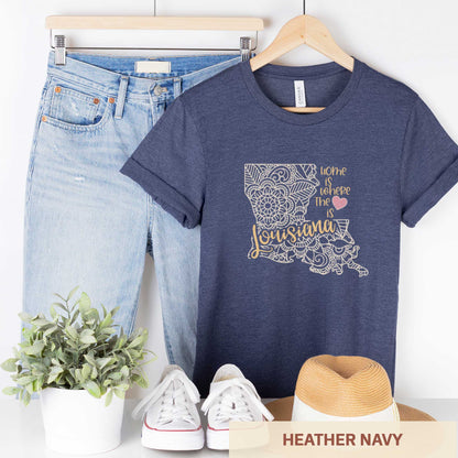 A hanging heather navy Bella Canvas t-shirt featuring a mandala in the shape of Louisiana with the words home is where the heart is.