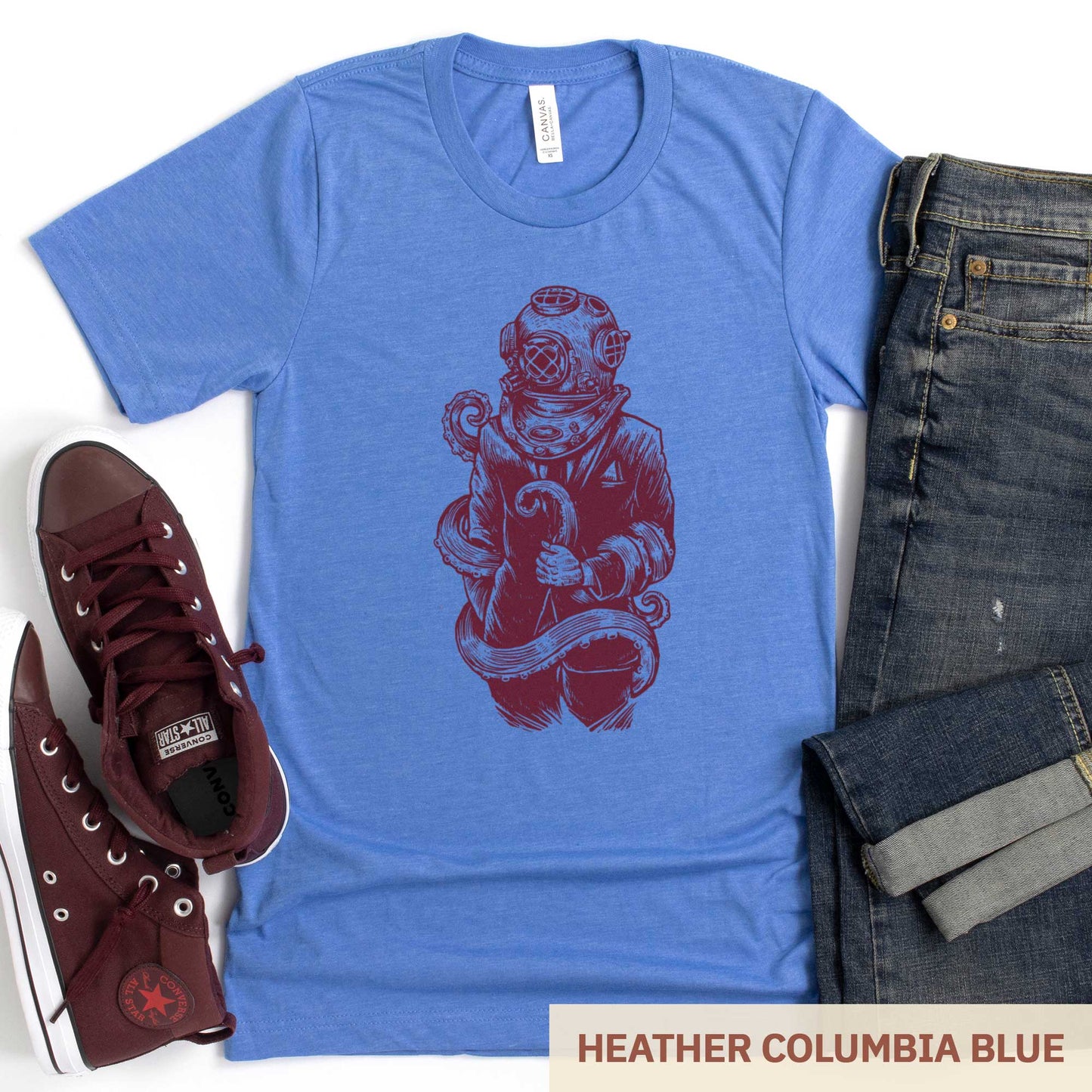 A heather columbia blue Bella Canvas t-shirt featuring a figure in a business suit wearing a vintage diver's helmet with octopus tentacles wrapped around them.