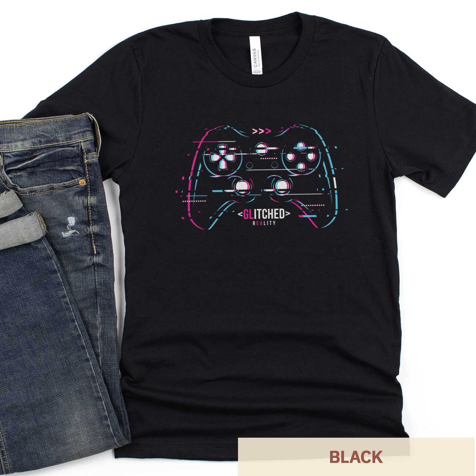 A black Bella Canvas t-shirt with a glitchcore video game controller with the words glitched reality.