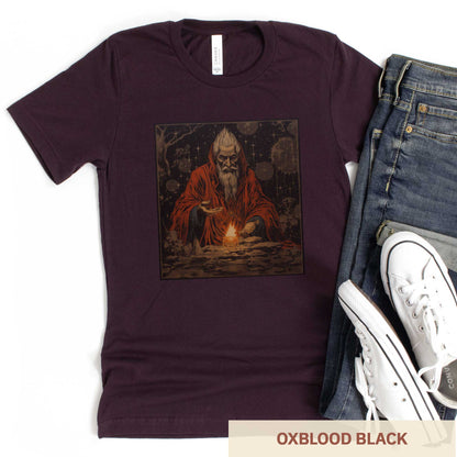 An oxblood black Bella Canvas t-shirt featuring a medieval looking sourcerer casting a spell over a small open flame.