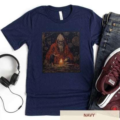 A navy Bella Canvas t-shirt featuring a medieval looking sourcerer casting a spell over a small open flame.