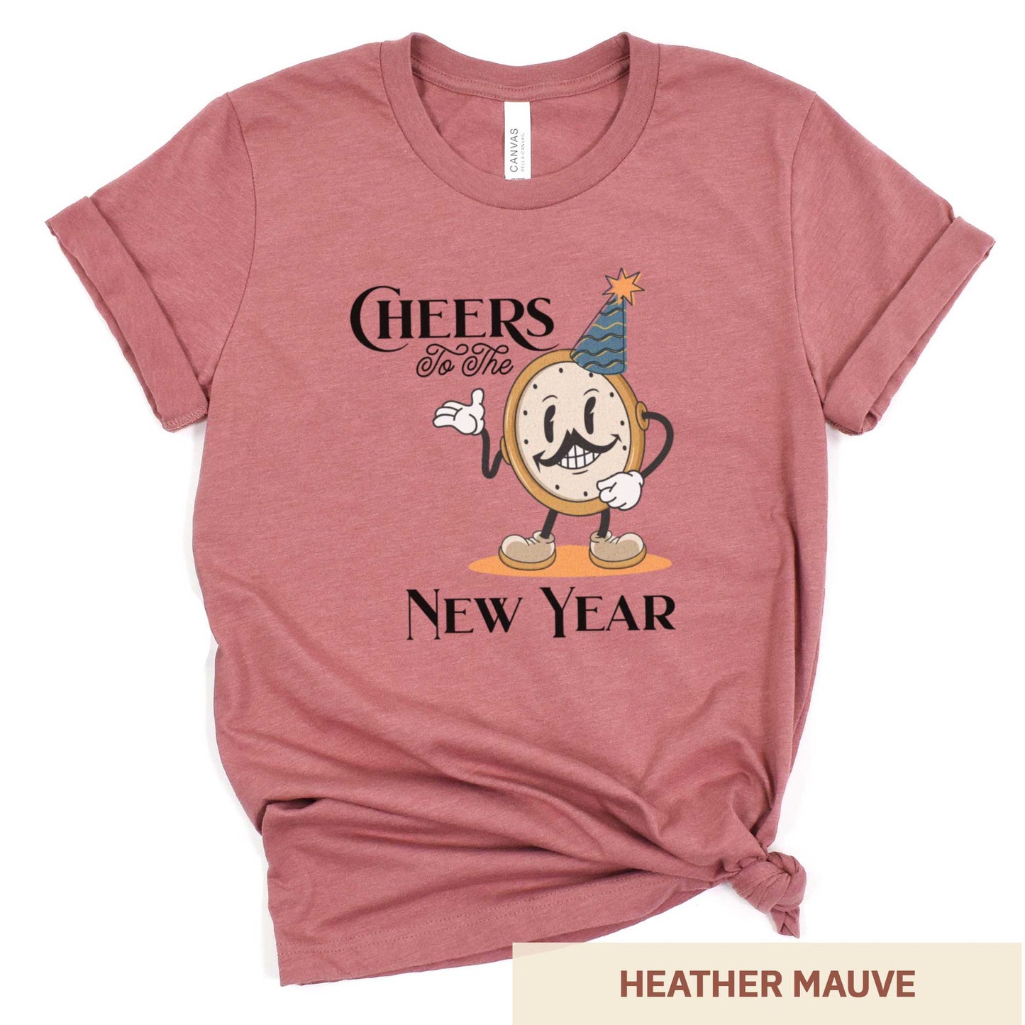 A heather mauve Bella Canvas t-shirt featuring a retro looking clock cartoon with a party hat next to the words Cheers to the New Year.