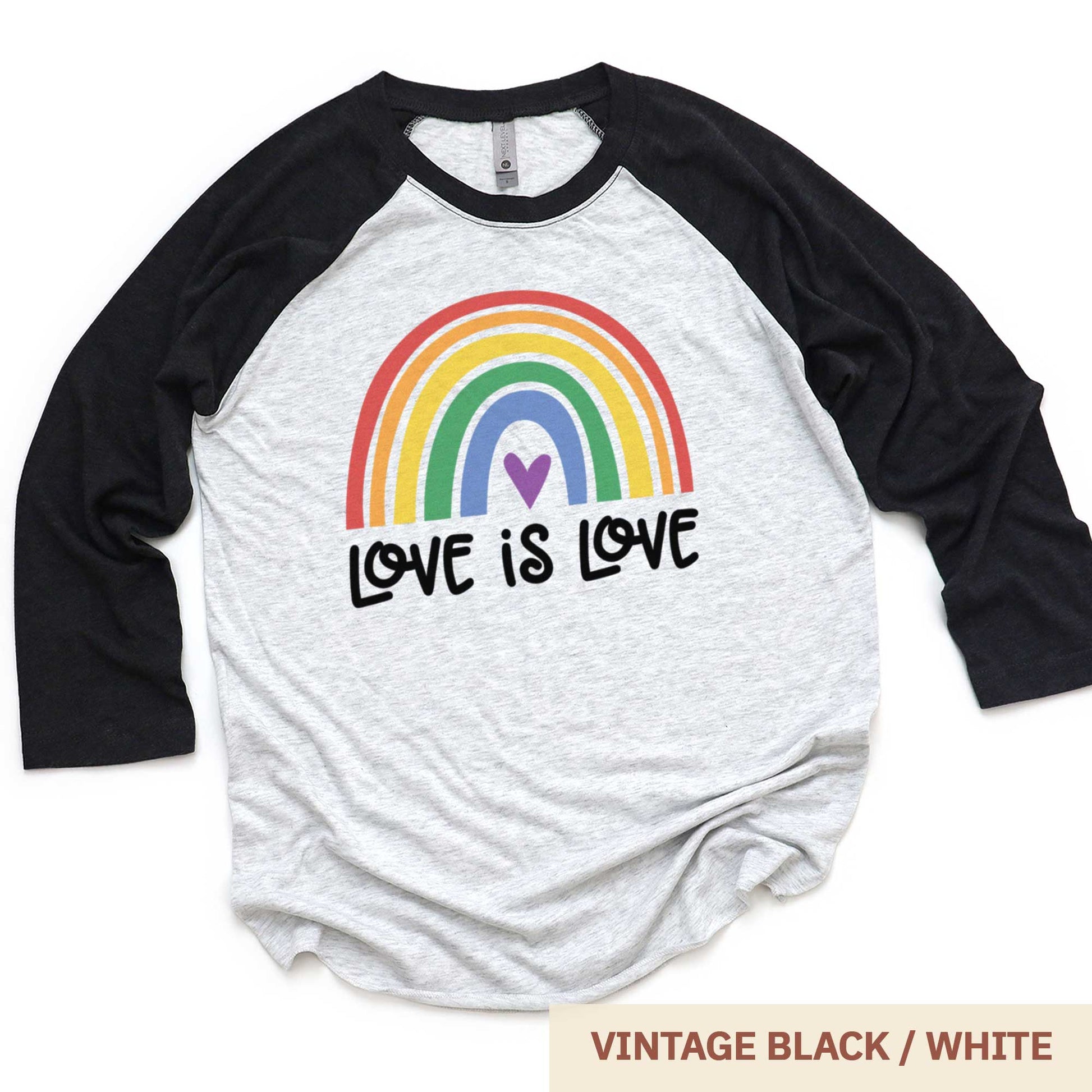A vintage black and heather white Next Level raglan swatch featuring a multi-colored rainbow with the words love is love below it.