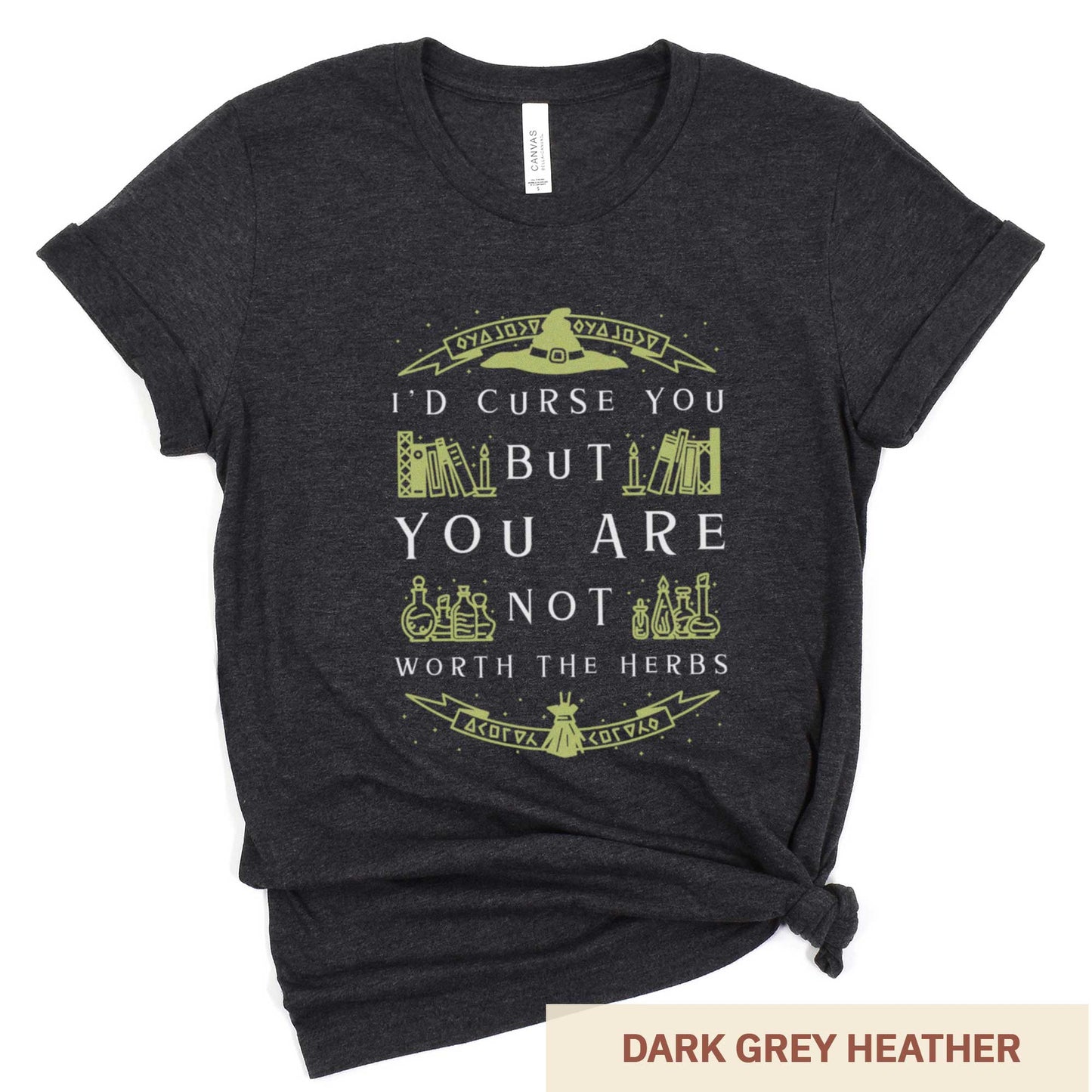 A dark grey heather Bella Canvas t-shirt with a witch's hat, books and potions and the words I'd curse you but you are not worth the herbs.