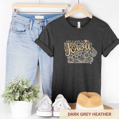 A hanging dark grey heather Bella Canvas t-shirt featuring a mandala in the shape of Iowa with the words home is where the heart is.