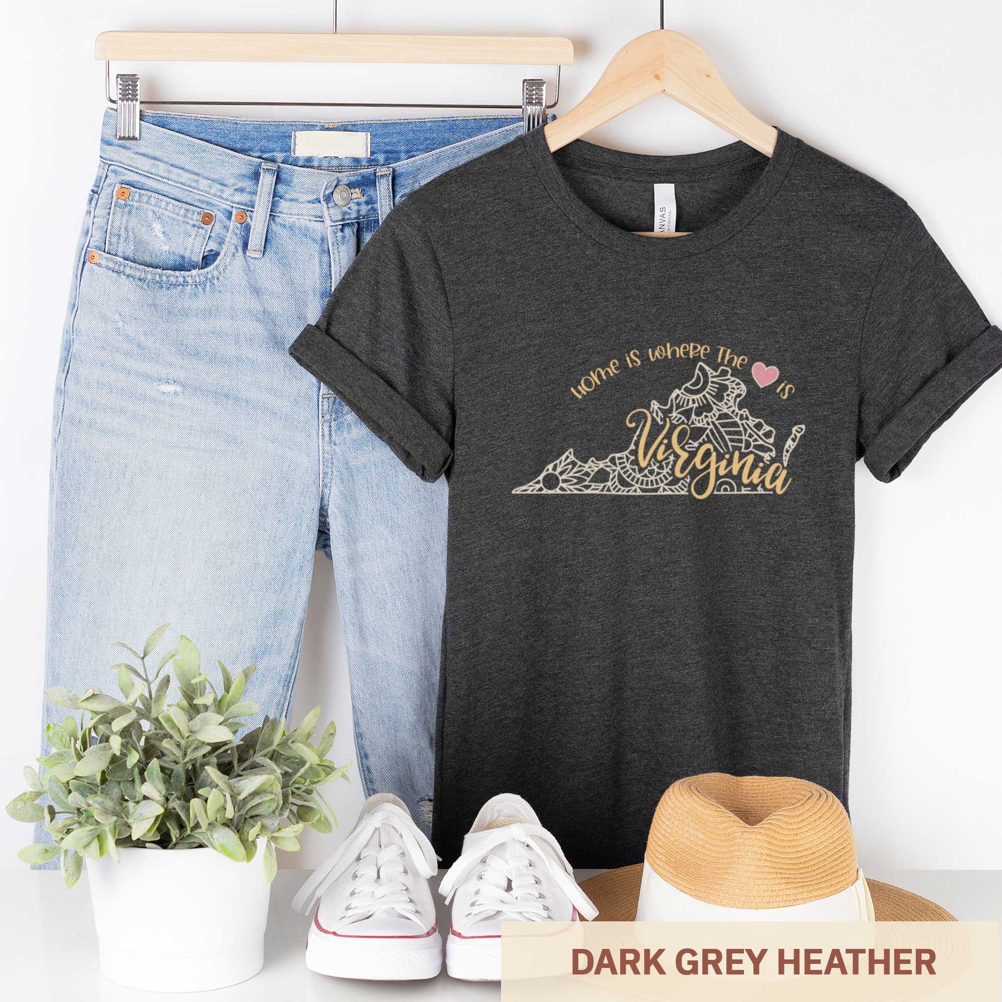 A hanging dark grey heather Bella Canvas t-shirt featuring a mandala in the shape of Virginia with the words home is where the heart is.