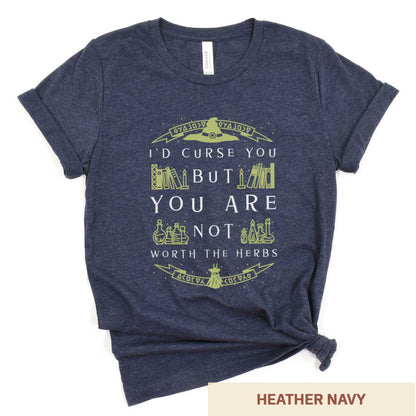 A heather navy Bella Canvas t-shirt with a witch's hat, books and potions and the words I'd curse you but you are not worth the herbs.