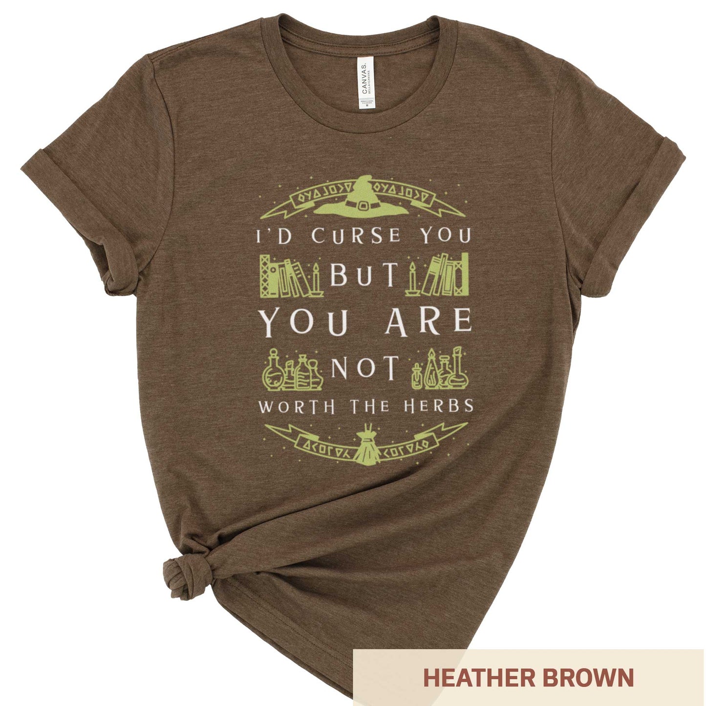 A heather brown Bella Canvas t-shirt with a witch's hat, books and potions and the words I'd curse you but you are not worth the herbs.