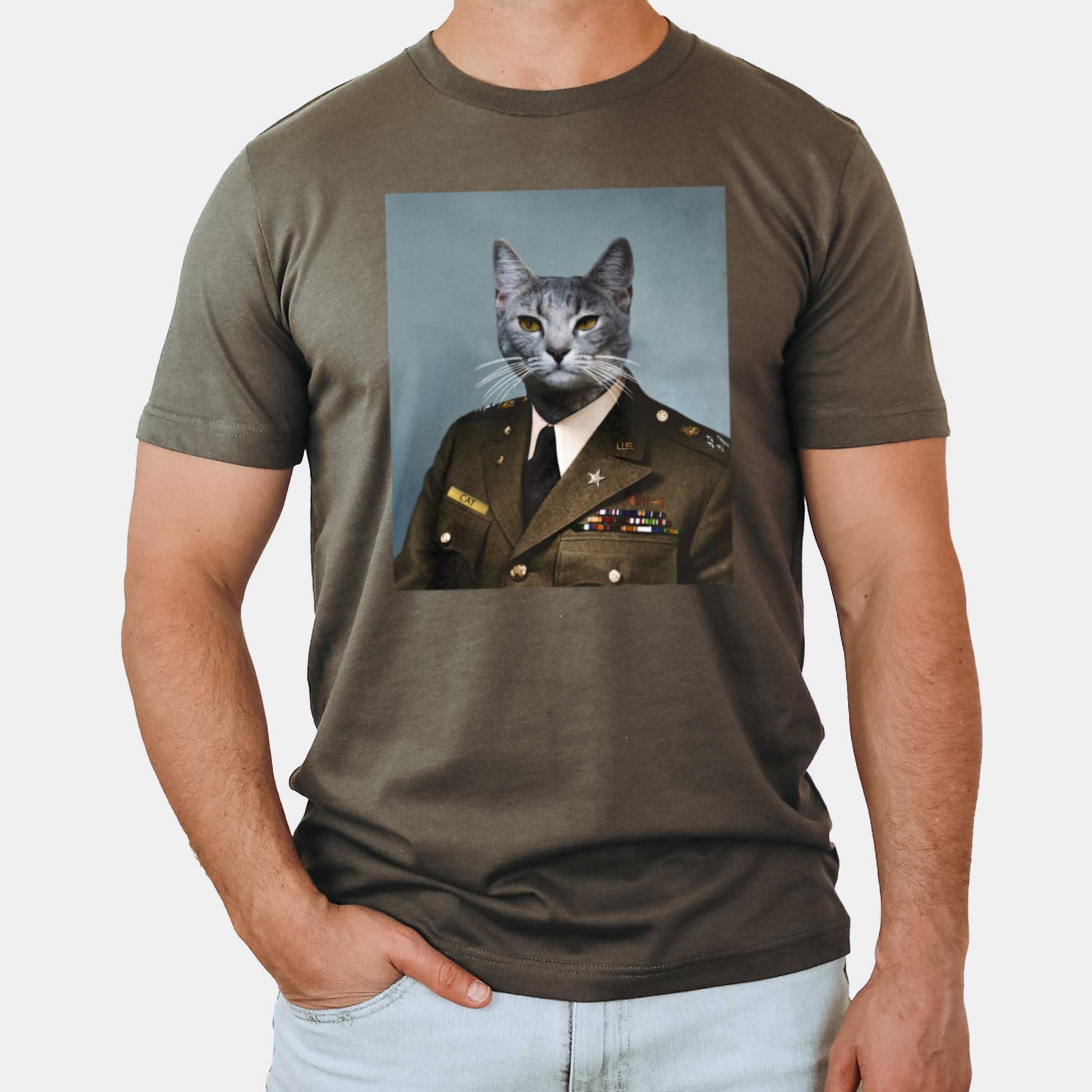 A man wearing an army green Bella Canvas t-shirt with a portrait of a grey cat as a U.S. army general.