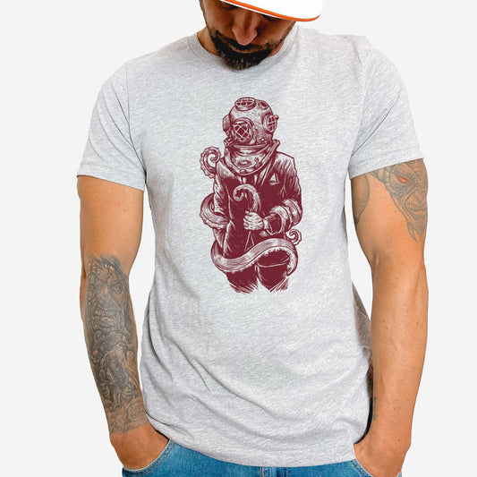 A man wearing an athletic heather Bella Canvas t-shirt featuring a figure in a business suit wearing a vintage diver's helmet with octopus tentacles wrapped around them.