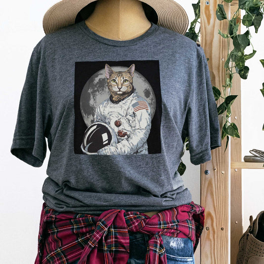 A mannequin wearing a deep heather grey Bella Canvas t-shirt featuring an illustrated portrait of a cat as a NASA astronaut with the moon in the background.