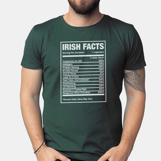 A man wearing a forest green Bella Canvas t-shirt that features a nutrition facts chart of Irish characteristics.