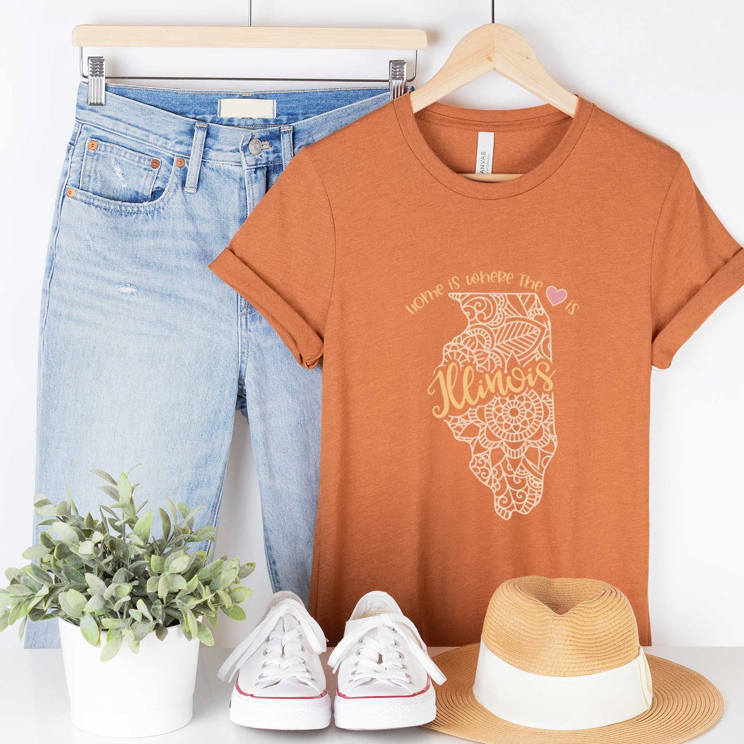 A hanging heather autumn Bella Canvas t-shirt featuring a mandala in the shape of Illinois with the words home is where the heart is.