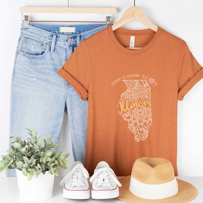 A hanging heather autumn Bella Canvas t-shirt featuring a mandala in the shape of Illinois with the words home is where the heart is.