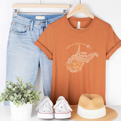 A hanging heather autumn Bella Canvas t-shirt featuring a mandala in the shape of West Virginia with the words home is where the heart is.