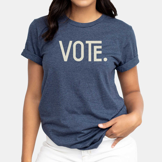 A woman wearing a heather navy Bella Canvas t-shirt with the words vote on it.