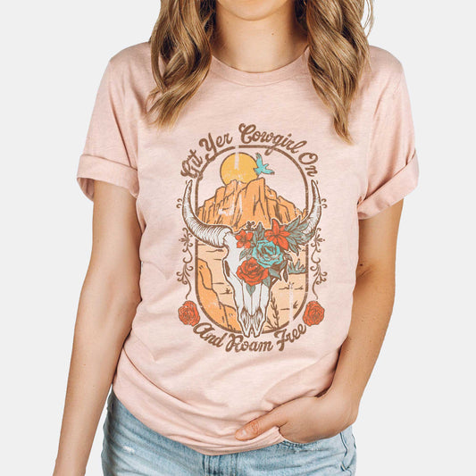 A woman wearing a heather prism peach Bella Canvas t-shirt featuring a cow skull that says git yer cowgirl on.