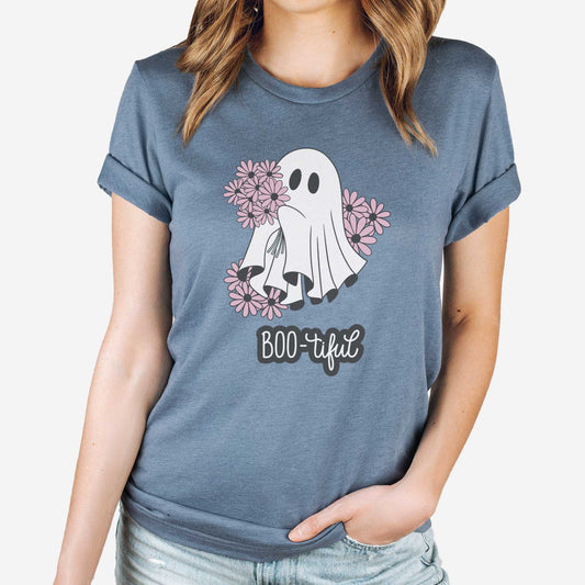 A woman wearing a heather slate Bella Canvas t-shirt featuring a cute cartoon ghost surrounded by flowers and the words boo-tiful.