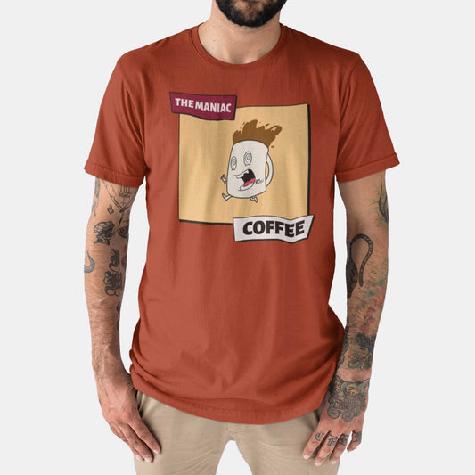 A man wearing a rust orange Bella Canvas t-shirt featuring a cartoon of a crazed coffee mug with the words the maniac coffee.