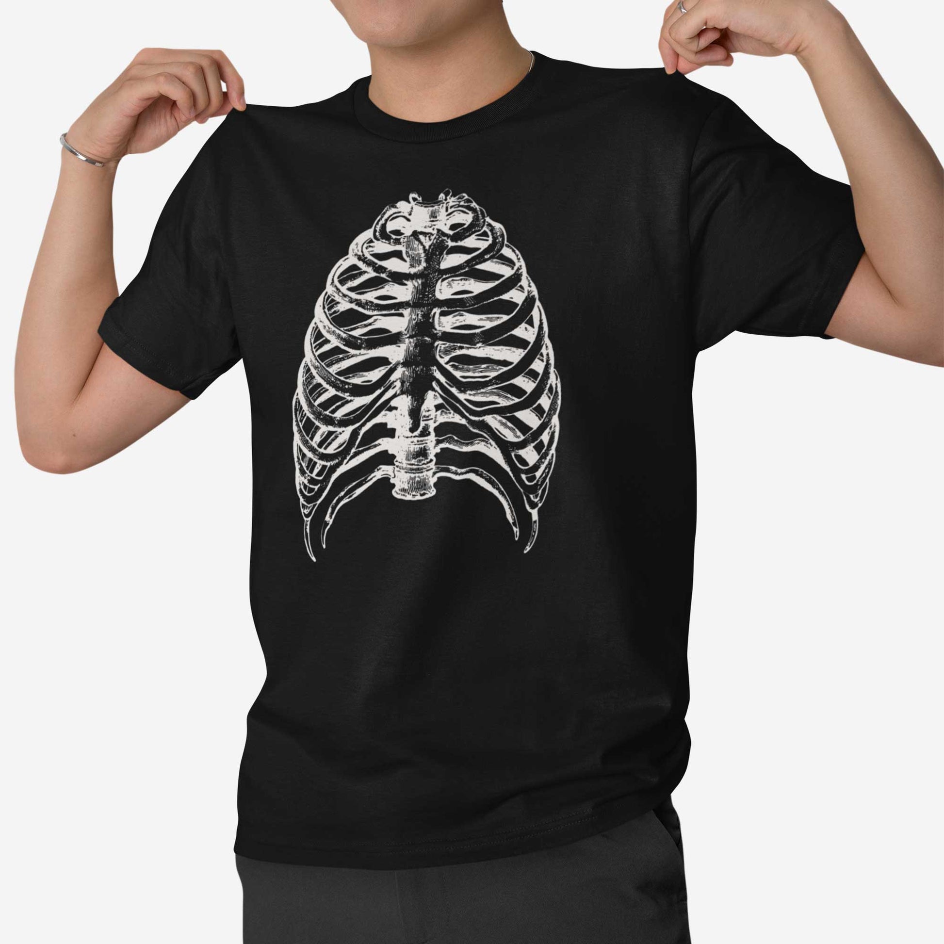 A man wearing a vintage black Bella Canvas t-shirt featuring a vintage illustration of a skeletons rib cage.