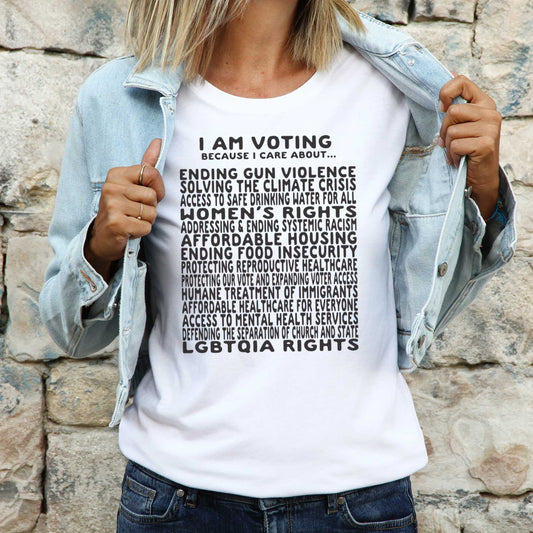 A woman wearing a white Bella Canvas t-shirt featuring a long list of issues she is voting on.