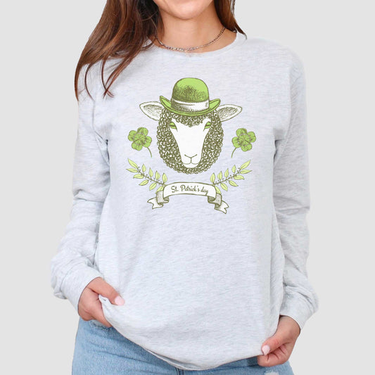 A woman wearing a long sleeved ash Bella Canvas t-shirt featuring a sheep with a green hat, clovers and the words St.Patrick's Day.