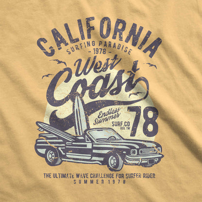 A mustard yellow Comfort Colors swatch with surfboards inside a convertible and the words California west coast surfing paradise